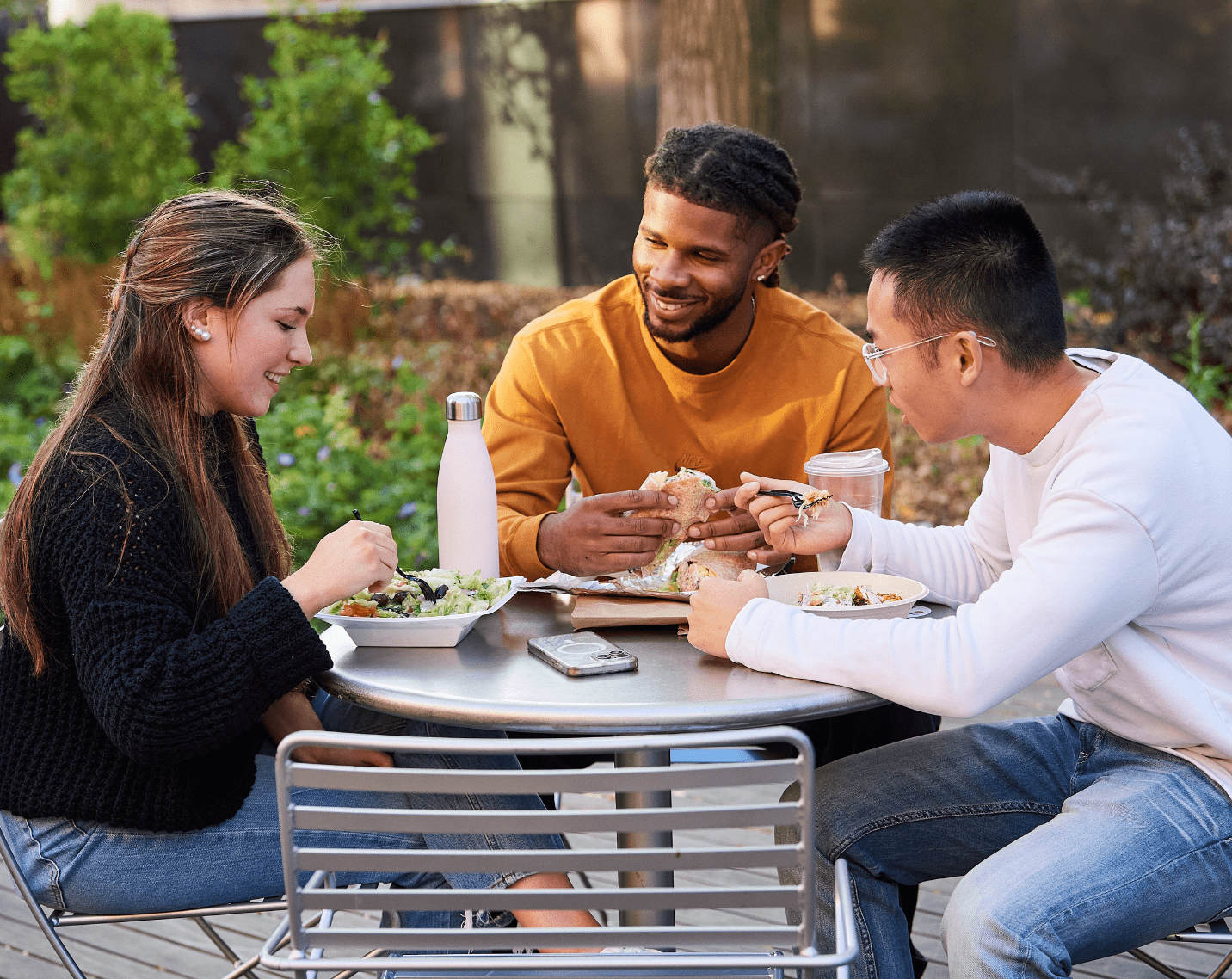 Students sitting at a table enjoying a meal. 